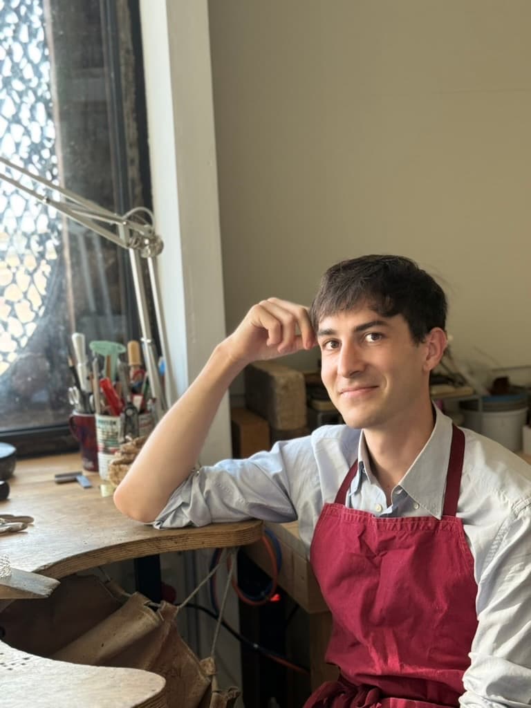 Robin Deriaz at the jeweller's bench, looking toward the camera